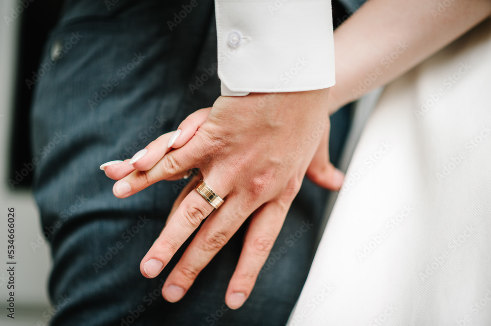 The bride and groom go ahead and walking, holding hands on a stroll along the street in the city. Bottom view. Newlyweds of the outdoors. The bride and groom go ahead and walking, holding hands on a stroll along the street in the city. Bottom view. Newlyweds of the outdoors.