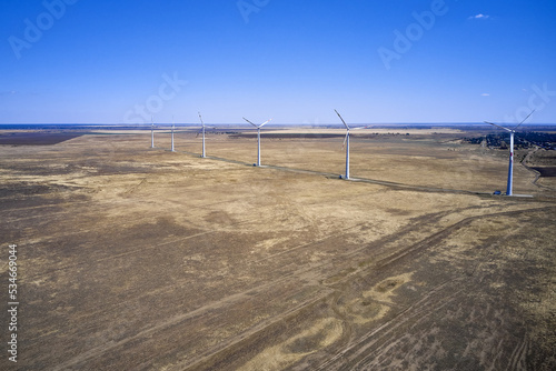 wind power plant in the steppe against the blue sky shooting from a drone