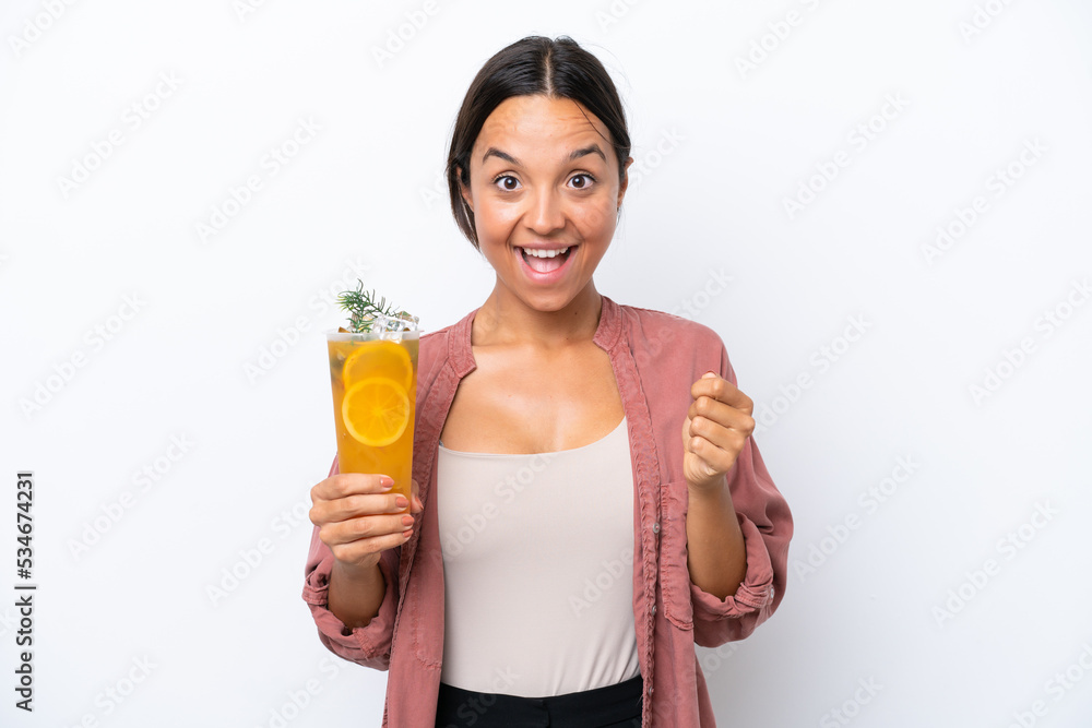Young hispanic woman holding a cocktail isolated on white background celebrating a victory in winner position Young hispanic woman holding a cocktail isolated on white background celebrating a victory in winner position