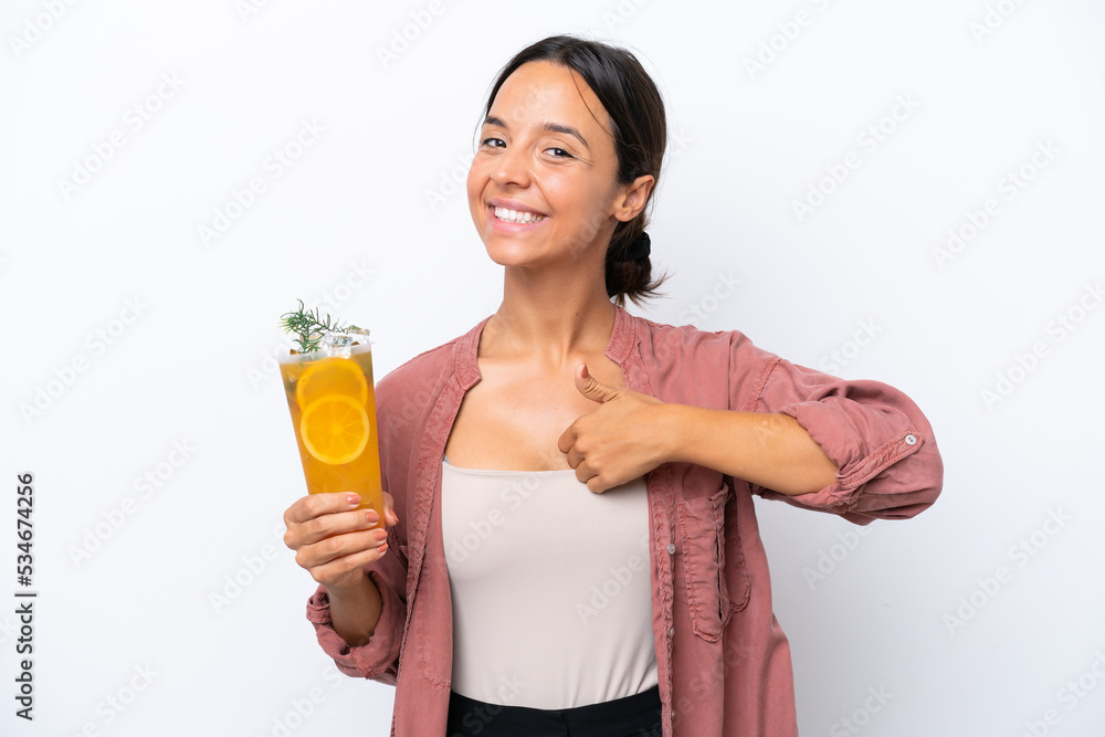 Young hispanic woman holding a cocktail isolated on white background giving a thumbs up gesture Young hispanic woman holding a cocktail isolated on white background giving a thumbs up gesture
