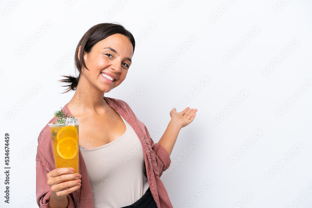 Young hispanic woman holding a cocktail isolated on white background extending hands to the side for inviting to come Young hispanic woman holding a cocktail isolated on white background extending hands to the side for inviting to come