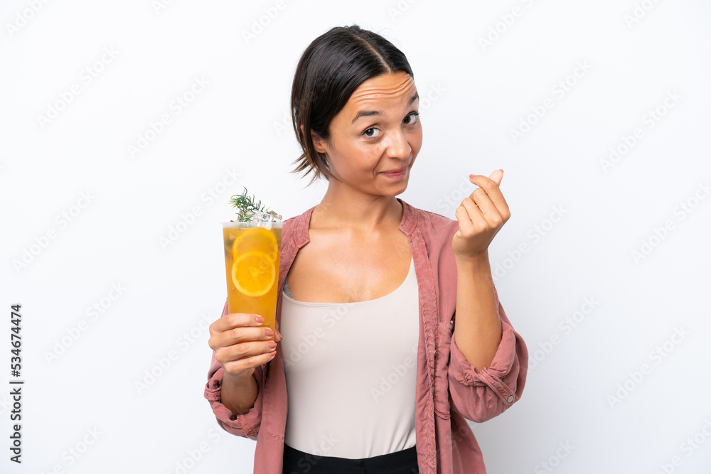 Young hispanic woman holding a cocktail isolated on white background making money gesture Young hispanic woman holding a cocktail isolated on white background making money gesture