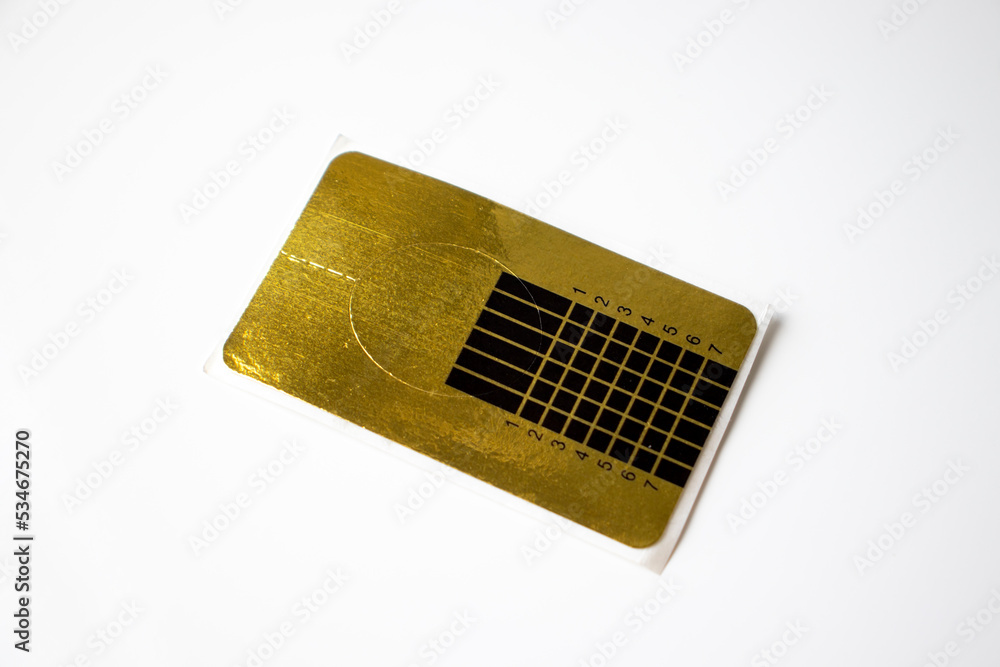 Paper form for nail extensions in gold on white background Paper form for nail extensions in gold on white background