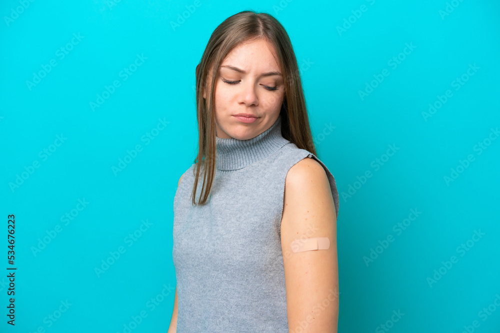 Young Lithuanian woman wearing band aids isolated on blue background with sad expression Young Lithuanian woman wearing band aids isolated on blue background with sad expression