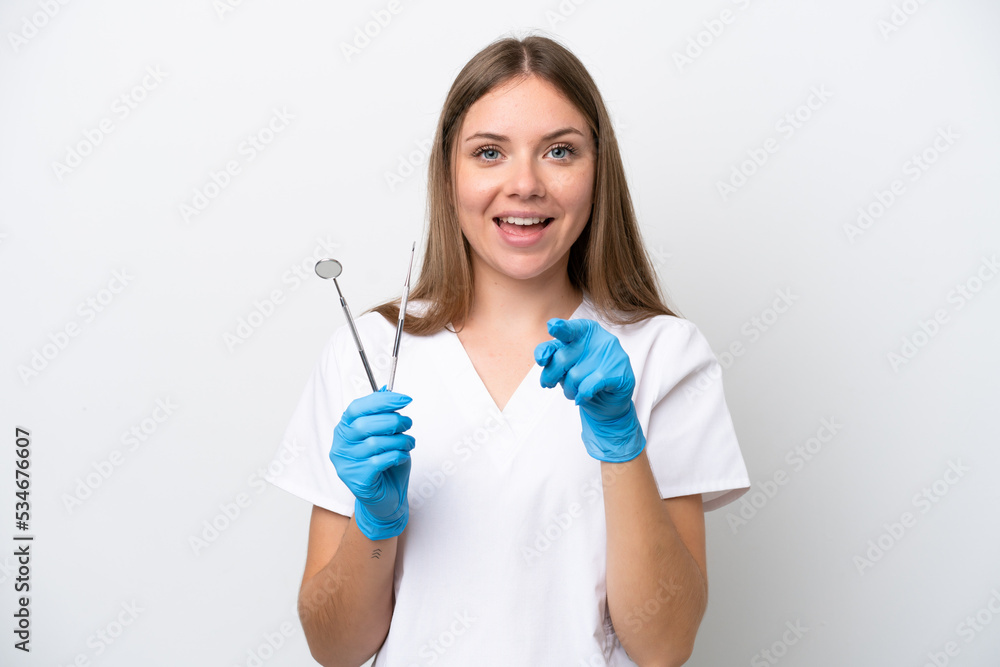 Dentist woman holding tools isolated on white background surprised and pointing front Dentist woman holding tools isolated on white background surprised and pointing front