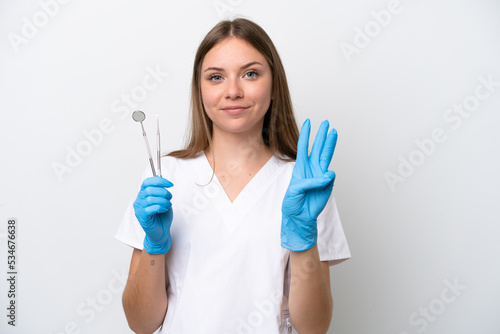 Dentist woman holding tools isolated on white background happy and counting three with fingers