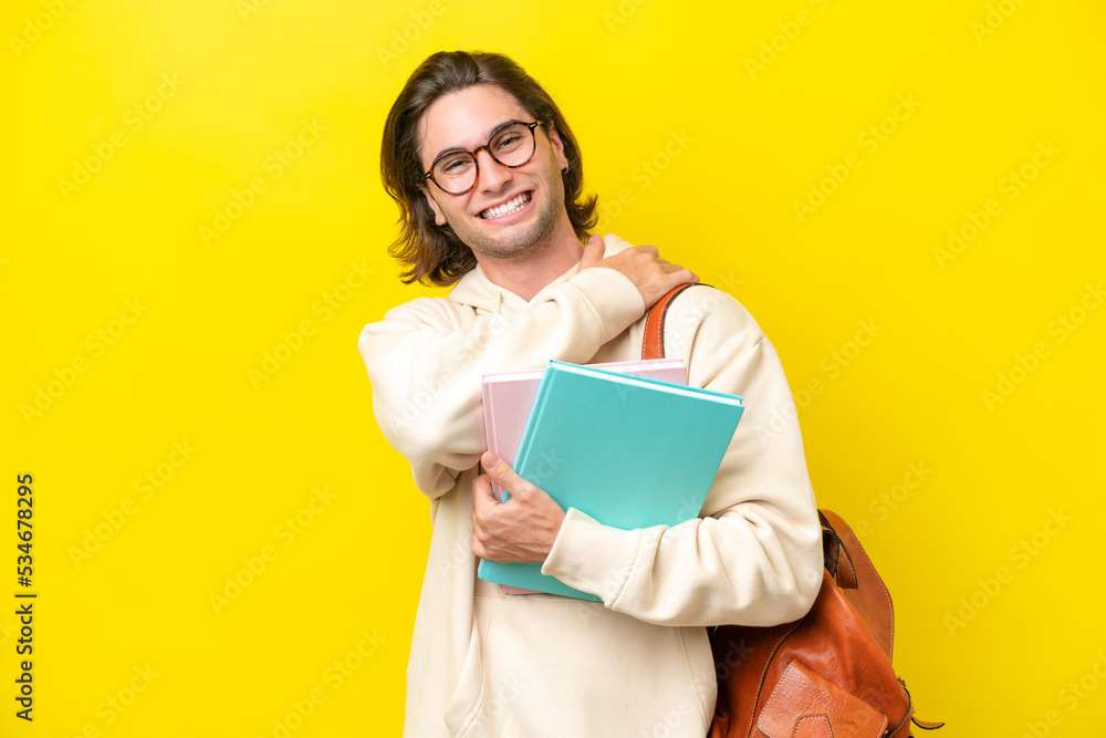 Young student handsome man isolated on yellow background laughing Young student handsome man isolated on yellow background laughing