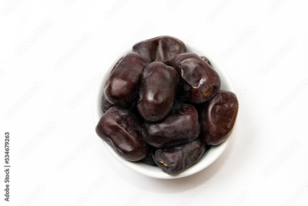 Fresh dates fruit in a white bowl on white background Fresh dates fruit in a white bowl on white background