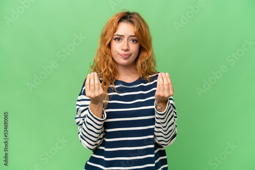 Young caucasian woman isolated on green screen chroma key background making money gesture but is ruined