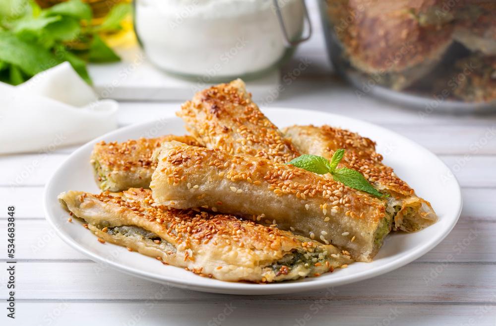 Greek cuisine dishes; spanakopita Sesame on handmade spinach feta cheese pie in the oven. Turkish name; ispanakli borek Greek cuisine dishes; spanakopita Sesame on handmade spinach feta cheese pie in the oven. Turkish name; ispanakli borek