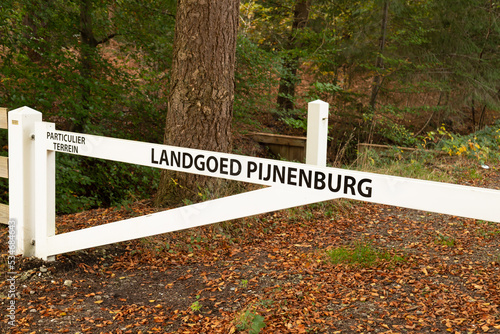 White wooden fence with the text Landgoed Pijnenburg (estate Pijnenburg) Particulier terrein (Private land). photo