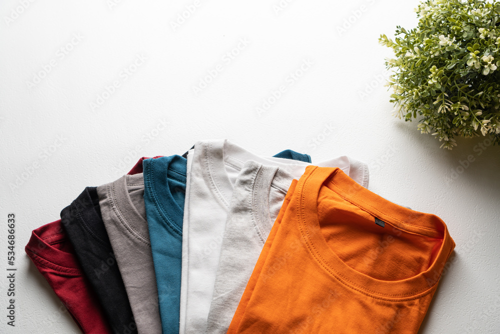 A collection of colorful plain t-shirts photographed from above. A collection of colorful plain t-shirts photographed from above.