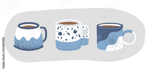A set of handmade mugs. Tea and coffee in beautiful stylish cups. Patterns on ceramic dishes