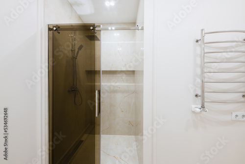 bathroom interior design with light tiles and glass shower