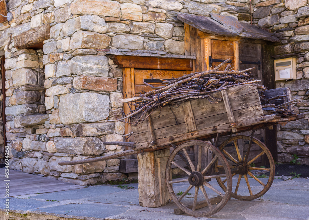 Obraz premium Bonneval-sur-Arc, France - September 18, 2022: Cart full of firewood in front of a house in the village.