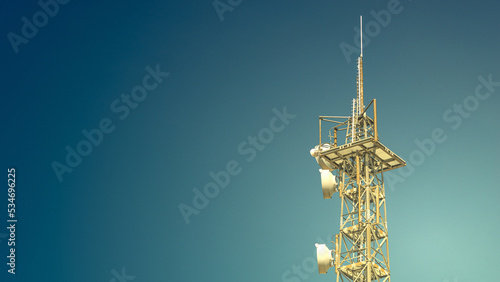Banner with telecommunication tower with many transmitters and receivers for various radio frequencies and data transmission, including 5G and satellite at blue gradient sky.