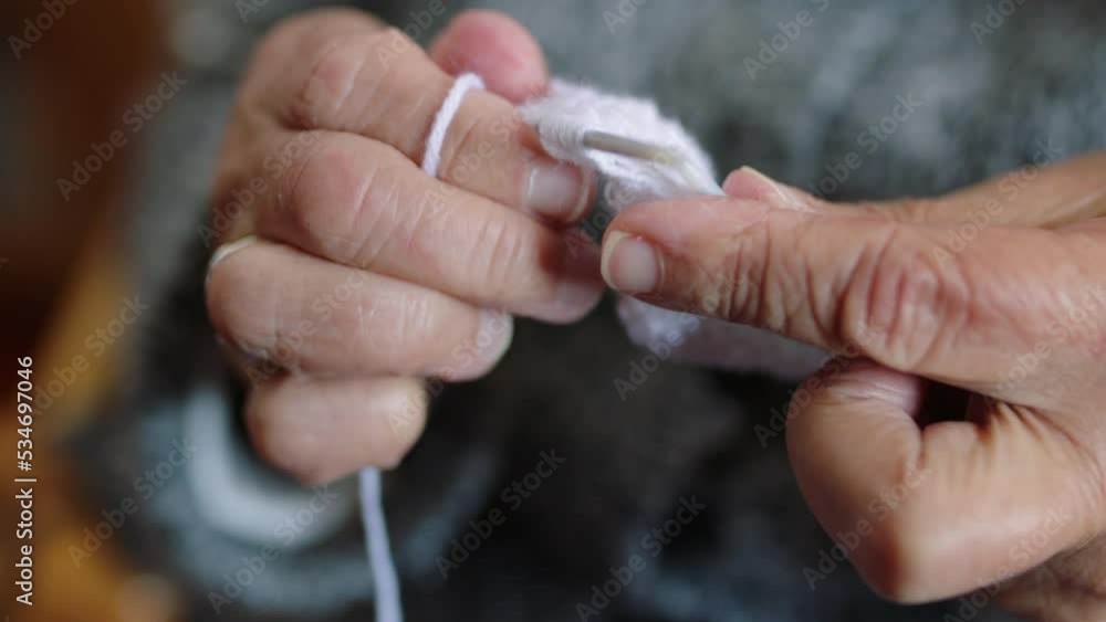 Hands of senior woman in retirement knitting, sewing and making a jersey, clothes or handmade scarf. Elderly retired female relaxing with free time for handicraft, hobby or handcraft at home or house Hands of senior woman in retirement knitting, sewing and making a jersey, clothes or handmade scarf. Elderly retired female relaxing with free time for handicraft, hobby or handcraft at home or house