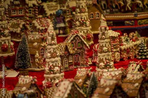 Advent Bazaar Stalls with glass, wooden, ceramic christmas souvenirs in shops. Close up of festive decorations for tree in winter street night market during new year's holiday. Illuminated fair kiosk © Defree