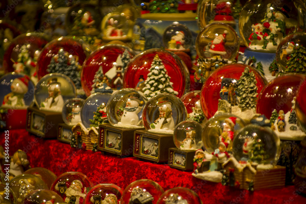 Advent Bazaar Stalls with glass, wooden, ceramic christmas souvenirs in shops. Close up of festive decorations for tree in winter street night market during new year's holiday. Illuminated fair kiosk Advent Bazaar Stalls with glass, wooden, ceramic christmas souvenirs in shops. Close up of festive decorations for tree in winter street night market during new year's holiday. Illuminated fair kiosk