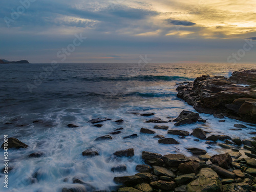 Dreamy soft-hued sunrise seascape over the ocean with high cloud