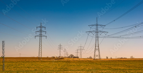 Photography Beautiful farm landscape and high voltage power lines pylons in Germany at Autumn colors during sunset with blue sky