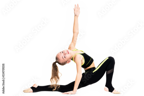Flexible little girl gymnast in black sports gymnastic suit does acrobatic exercises isolated on a white background with space for text or logo. Sport, workout, fitness, yoga, active lifestyle concept