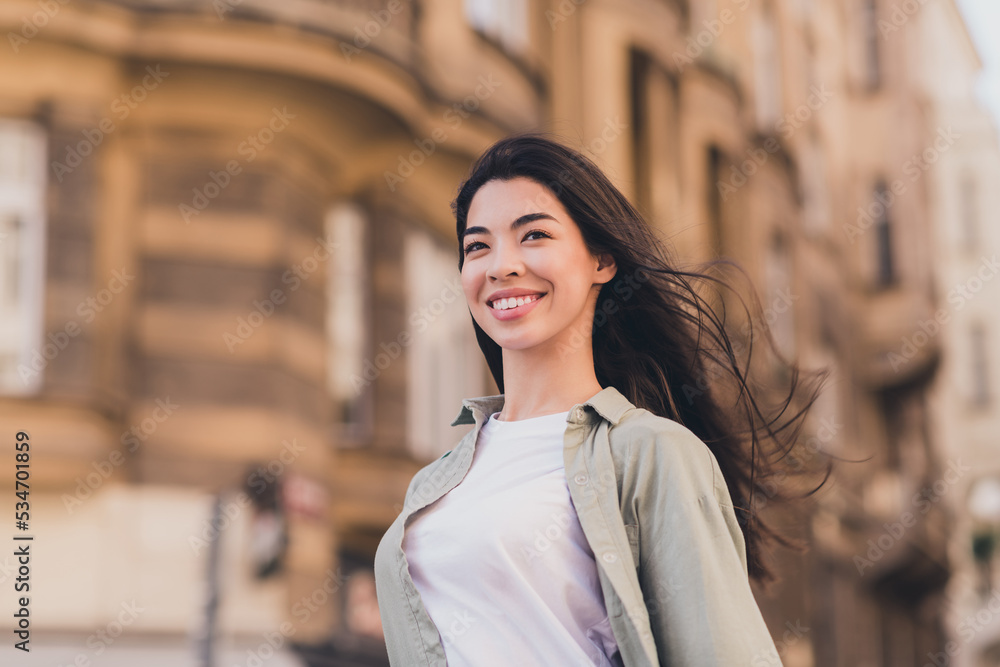 Photo of shiny cute young asian woman wear khaki shirt enjoying summer warm air sunshine city tour outside urban city street
