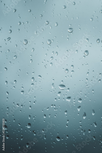 Close-up of rain drops on glass background. Premium colorful abstract background with dynamic shadow on background  consisting of water on glass  gradient color  artistic texture  epic  beautiful