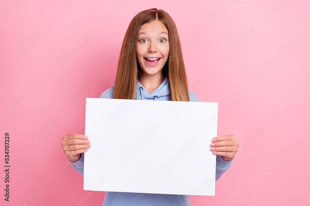 Closeup photo of young little cute pretty nice schoolkid wear blue sweater hold paper banner excited good mood isolated on pink color background Closeup photo of young little cute pretty nice schoolkid wear blue sweater hold paper banner excited good mood isolated on pink color background