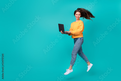 Full body size photo of young student woman wear stylish outfit hold laptop blogger youtube subscribe empty space isolated on cyan color background