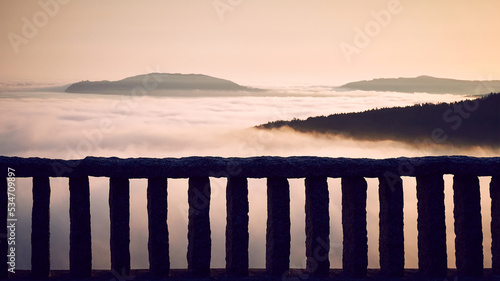 Cape Finisterre and its famous lighthouse surrounded by clouds and fog from the the viewpoint of Ezaro photo