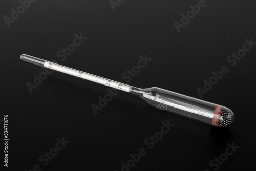 hydrometer, a tool for measuring the density of the battery electrolyte, on a black background photo