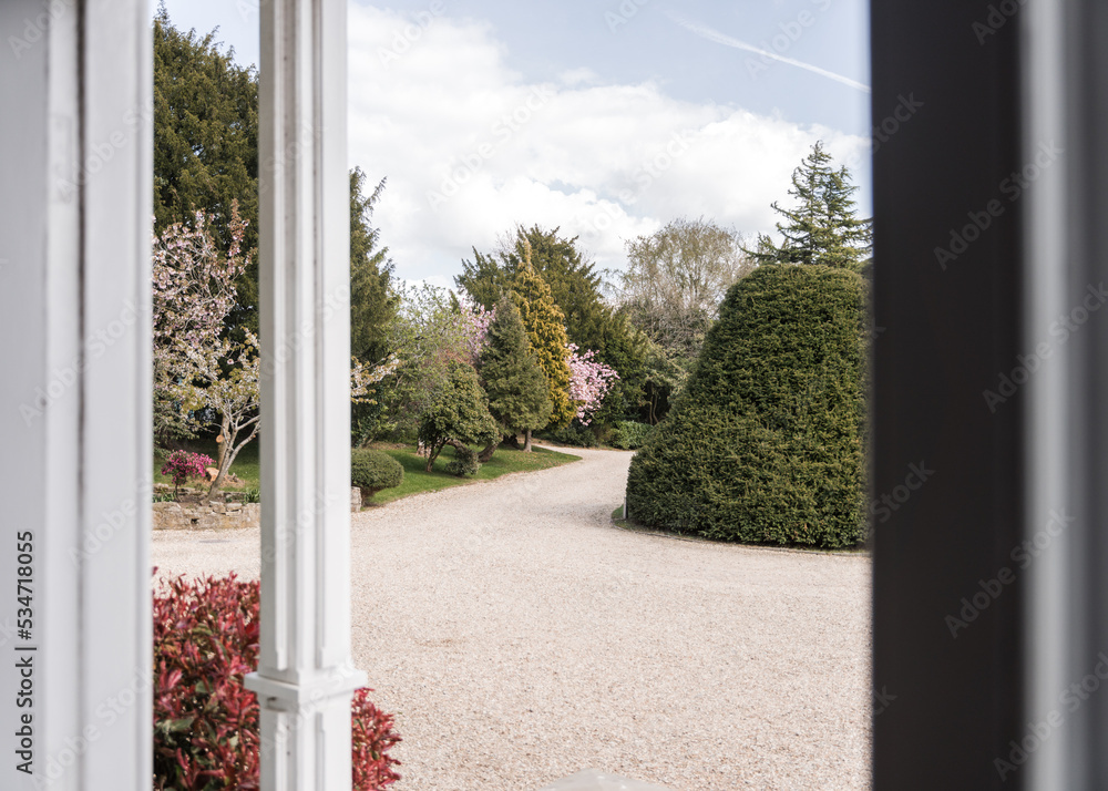 Naklejka premium Beautiful old house driveway on summer day winding through gardens