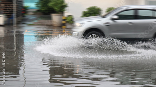 Blur car running and splashing flood water on the flooded street which caused by heavy rain and blocked drainage pipes. 