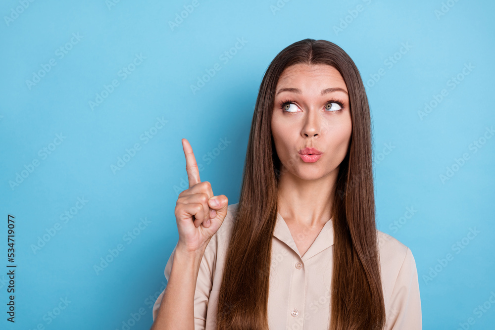 Portrait of gorgeous nice cute girl with long hairstyle dressed beige shirt indicating empty space isolated on blue color background Portrait of gorgeous nice cute girl with long hairstyle dressed beige shirt indicating empty space isolated on blue color background