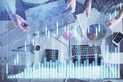 Double exposure of man and woman working together and financial chart hologram drawing. market analysis concept. Computer background. Top View.