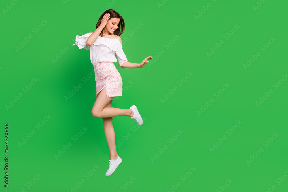 Full length portrait of stunning cheerful person jump empty space isolated on green color background Full length portrait of stunning cheerful person jump empty space isolated on green color background