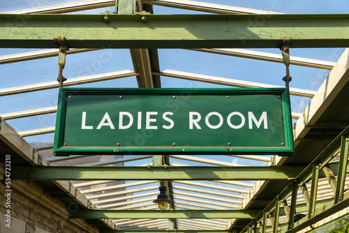 green ladies room sign on a train station  photo