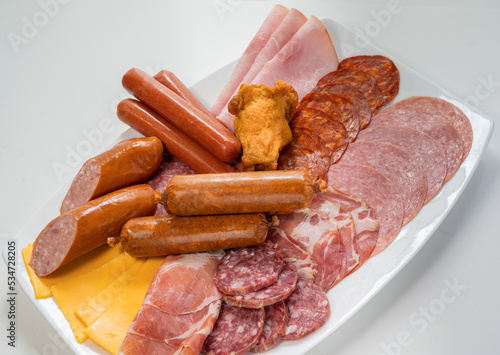Plate filled with unhealthy processed meats and cheese