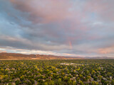 early morning with a rainbow  over Fort Collins and foothills of Rocky Mountains in northern Colorado, aerial view