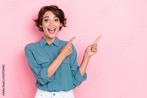 Portrait photo of young attractive pretty nice smiling woman finger pointing empty space advert good deal crazy isolated on pink color background © deagreez