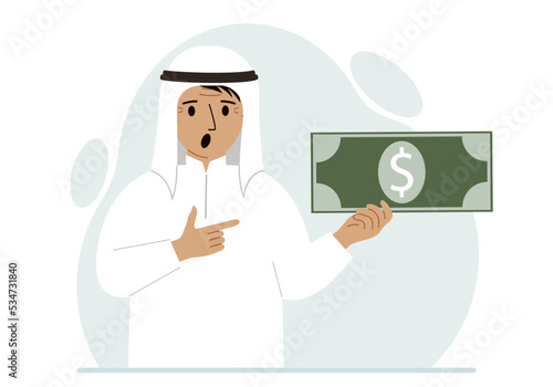 A arab man holds a large paper bill in his hand. The concept of income, expense, earning or spending money.