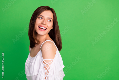 Portrait of pretty sweet tender lady summer outfit interested look stand empty space enjoy good mood isolated on green color background © deagreez