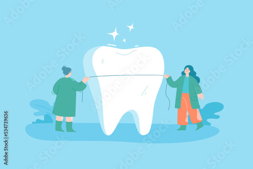 Tiny dentists with dental floss cleaning huge tooth. Cartoon women flossing teeth of patient flat vector illustration. Oral hygiene, dentistry, health concept for banner or landing web page
