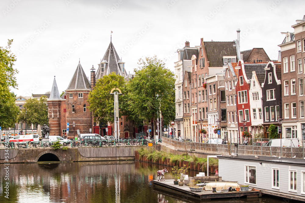 rincón de la ciudad europea de amsterdam con canal, casas flotantes, barcos, iglesia y edificios, holanda , países bajos