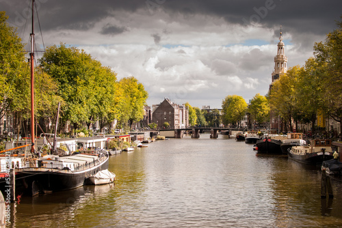 canal grande y ancho con embarcaciones a los lados en amsterdam, paises bajos