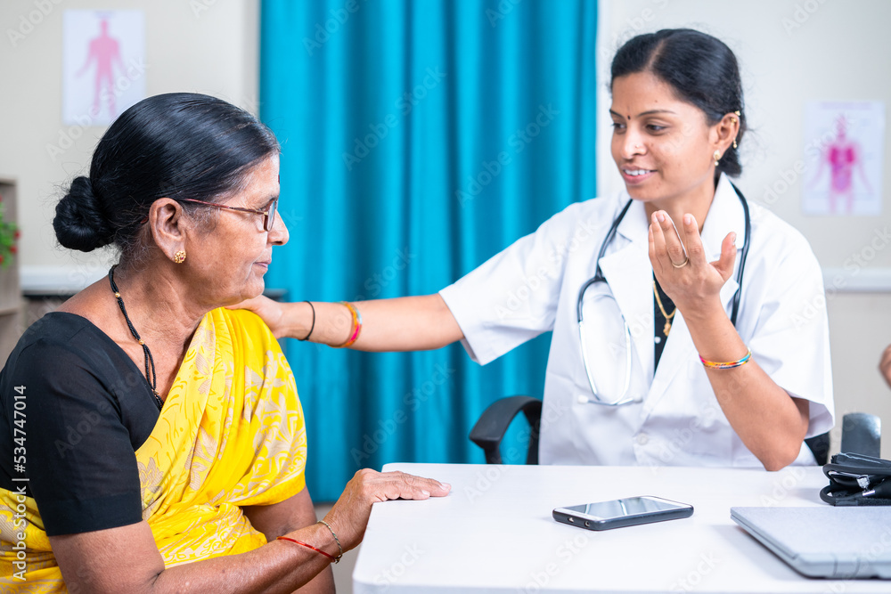 senior indian docter sugesting healthy tips or counsulting patient at hospital - concept of healthcare, professional occupation and mental illness therapy. senior indian docter sugesting healthy tips or counsulting patient at hospital - concept of healthcare, professional occupation and mental illness therapy.