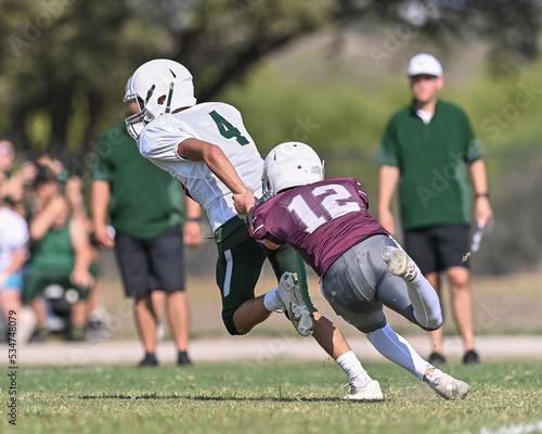 Young athletic tackle football players making great plays during a game