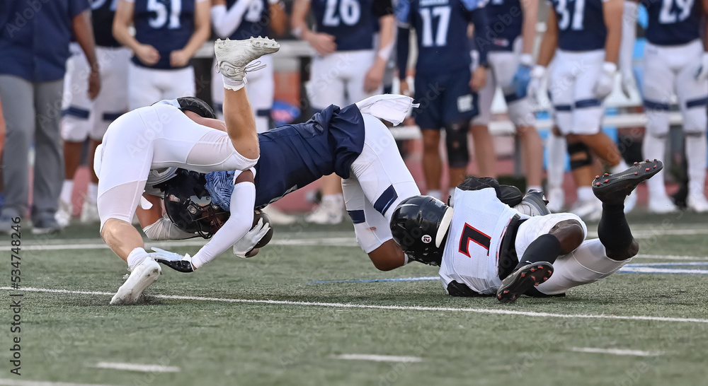 Fototapeta premium Young athletic tackle football players making great plays during a game