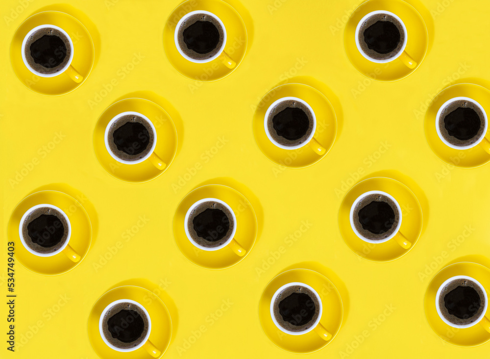Fototapeta premium Top view of yellow coffee cups on the yellow background. Pattern. Flay lay.